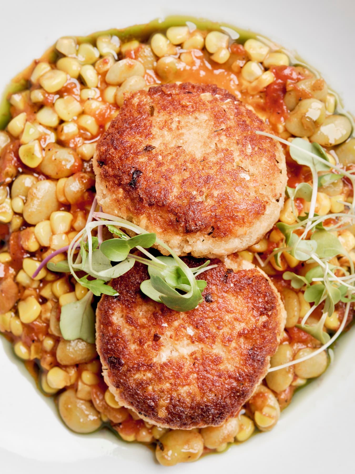 Golden crab cakes over succotash